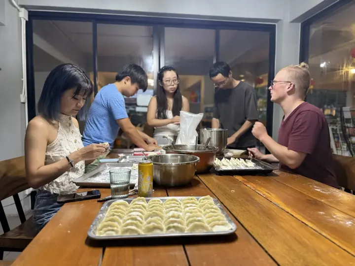 人们围在餐桌旁一起准备食物