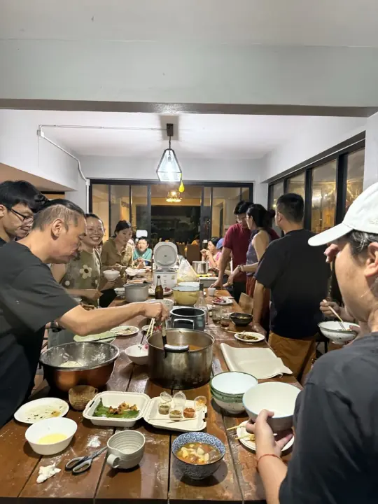 人们围在餐桌旁一起准备和分享食物